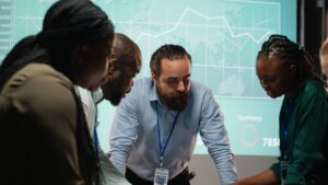 Team of professionals analyzing data and discussing strategies in front of a digital dashboard, illustrating collaborative decision-making in risk management.