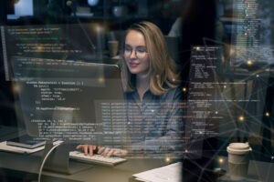 A female developer working on a computer with digital code overlays, representing the core concepts of software engineering.