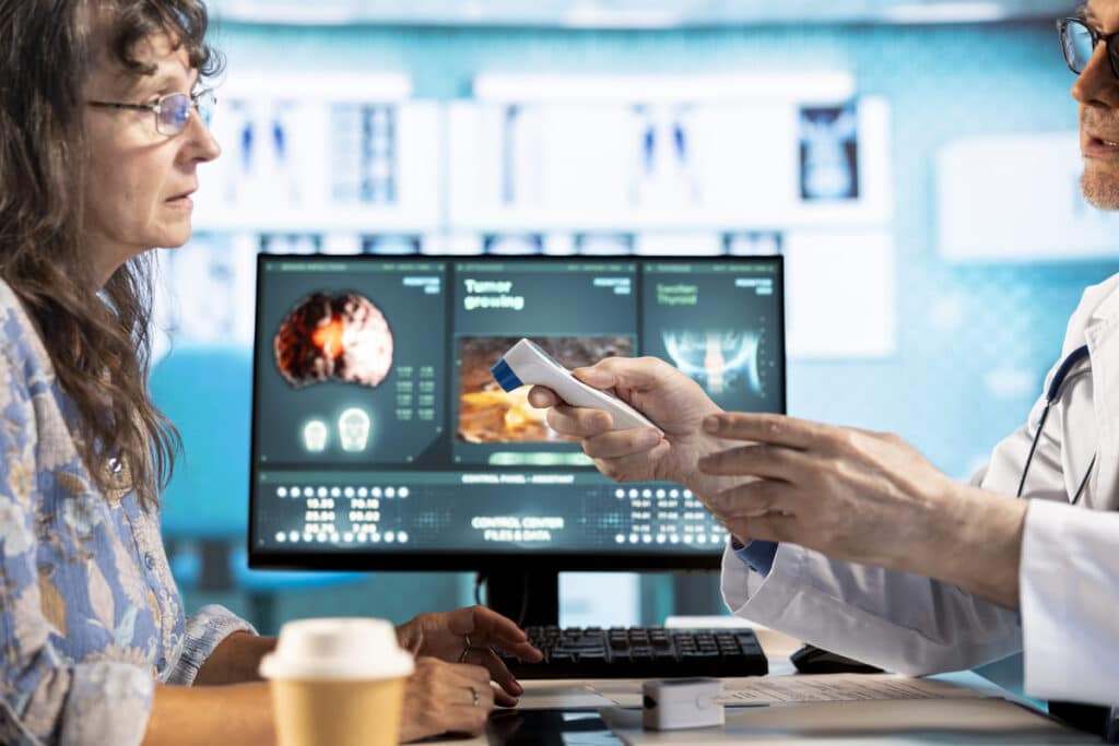 A doctor uses a digital medical device during a patient consultation, illustrating the impact of digital product engineering for healthcare.