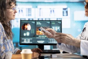 A doctor uses a digital medical device during a patient consultation, illustrating the impact of digital product engineering for healthcare.