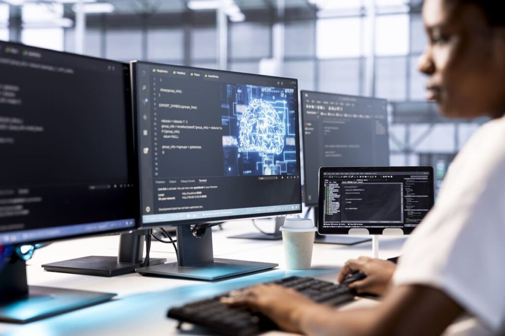 Person coding with screens displaying a brain icon for AI-driven software engineering.