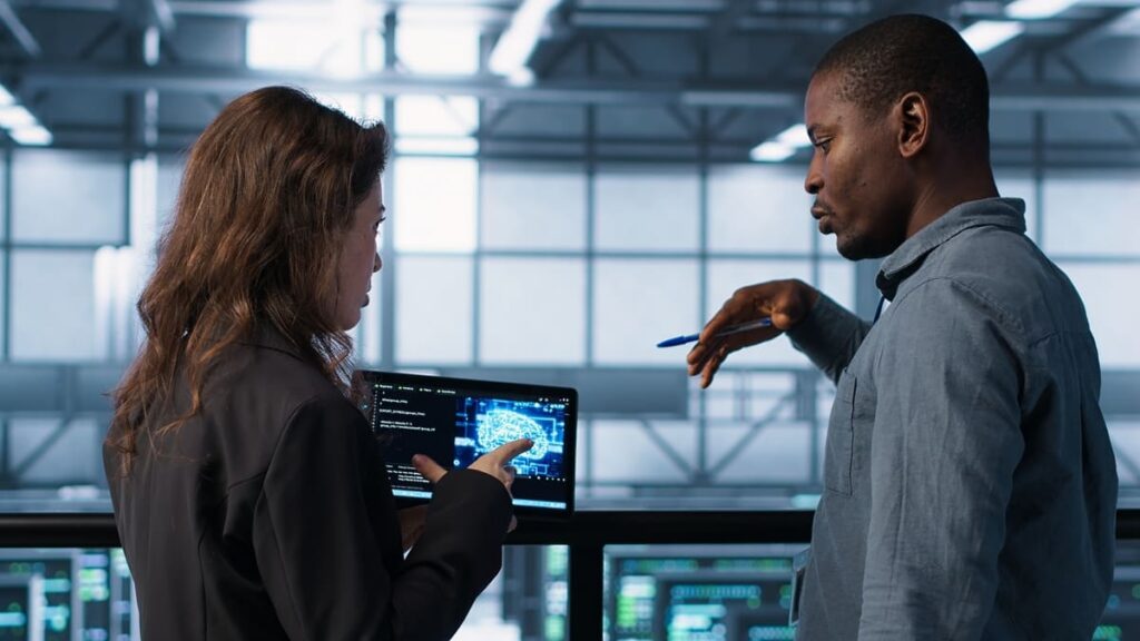 Two coworkers analyze tech data, showing the challenges enterprises face in implementing IA.
