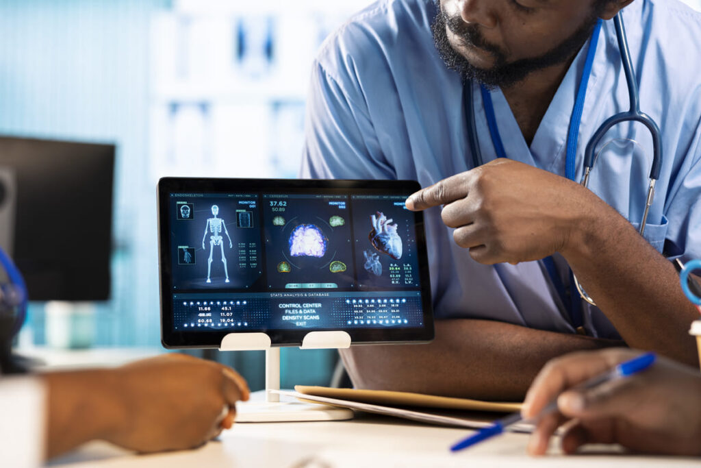 Doctor points at medical scans on a tablet, illustrating cloud migration in healthcare.
