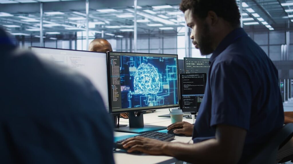 Man looks at a monitor with a digital brain graphic to compare RPA vs. Agentic AI.